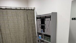 A bathroom with a toilet, sink, and storage cabinets.