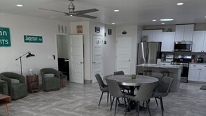 A modern kitchen with white cabinets, a stainless steel refrigerator, and a microwave.