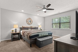 A bedroom with a bed, nightstands, a ceiling fan, a window with blinds, and a TV stand. - Caddy Shack | Pointe Royale 3BR Condo w/ Pools + Golf Views (PR 61-8) (Branson)