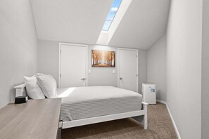 A bedroom with a bed, a desk, a trash bin, and a skylight. - Caddy Shack | Pointe Royale 3BR Condo w/ Pools + Golf Views (PR 61-8) (Branson)