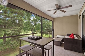 A room with a table, chairs, a sofa, and a ceiling fan. - Caddy Shack | Pointe Royale 3BR Condo w/ Pools + Golf Views (PR 61-8) (Branson)