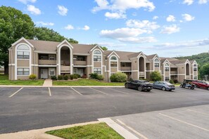 Un immeuble d’appartements à plusieurs étages avec un parking situé devant.