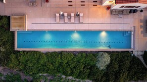 Ein Pool auf dem Dach mit Liegestühlen und einem kleinen Tisch.