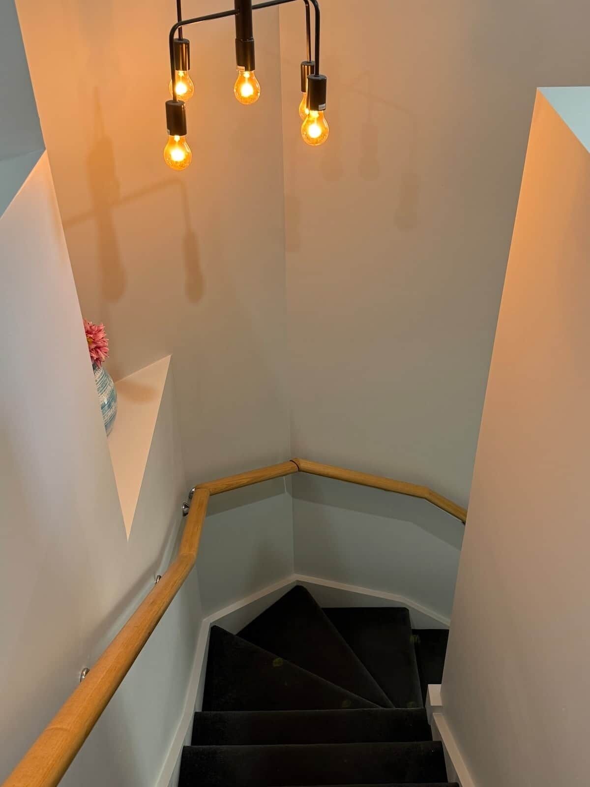Eine Treppe mit Holzwahnschienen und einem mit Teppich ausgelegten Boden.