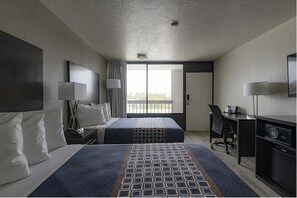 Ein Hotelzimmer mit einem großen Bett, einem Schreibtisch, einem Stuhl und einem Fernseher.