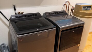 Lavadora y secadora compacta con panel de control, entrada de agua y salida de agua.