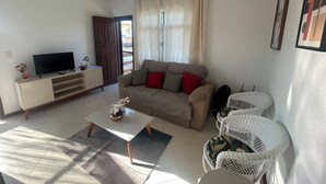 Ein Wohnzimmer mit Sofa, Couchtisch, Fernseher und Deckenventilator.