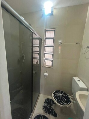 A bathroom with a glass shower enclosure, a toilet, and a bidet. - Apartment for rent in Cabo Frio (Cabo Frio)