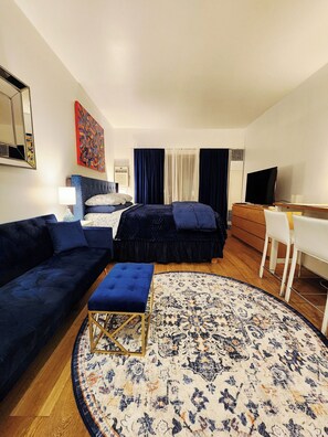 A hotel room with a bed, a sofa, a desk, a TV, and a large rug. - 1-bedroom Ski retreat Pool hottub by Historic Main RailTrail on Ski In/Out shutl (Park City)