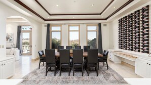 A dining area with a large table, chairs, and a wine rack. - The Estate Villa at Dresser Winery by Avantstay Pool + Sauna Paso Robles (Paso Robles)