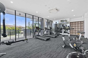 A gym with treadmills, elliptical machines, and a rowing machine. - Sandbar Burleigh - Ocean Delight (Gold Coast)