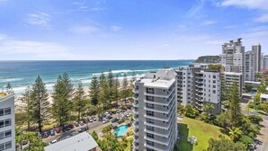 A coastal hotel with multiple high-rise buildings, a swimming pool, and a view of the ocean. - Sandbar Burleigh - Ocean Delight (Gold Coast)