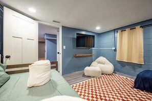 Ein Schlafzimmer mit Bett, Fernseher und einem Badezimmer mit Duschvorhang, sowie einem Flur.
