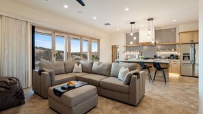 A modern living room with a sectional sofa, a coffee table, and a view of the kitchen. - Mission de los Robles by Avantstay Vineyard Views + King Suites + Patio Paso Robles Wine Country (Paso Robles)