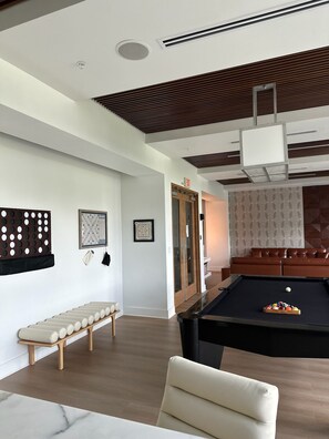 Un salon moderne avec une table de billard, un banc et un canapé.