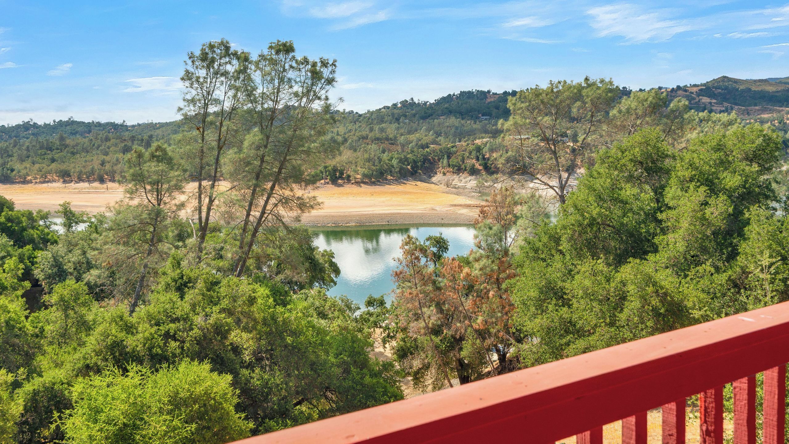 A view of a lake surrounded by dense greenery and hills.