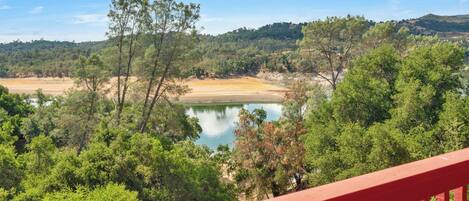 A view of a lake surrounded by dense greenery and hills.