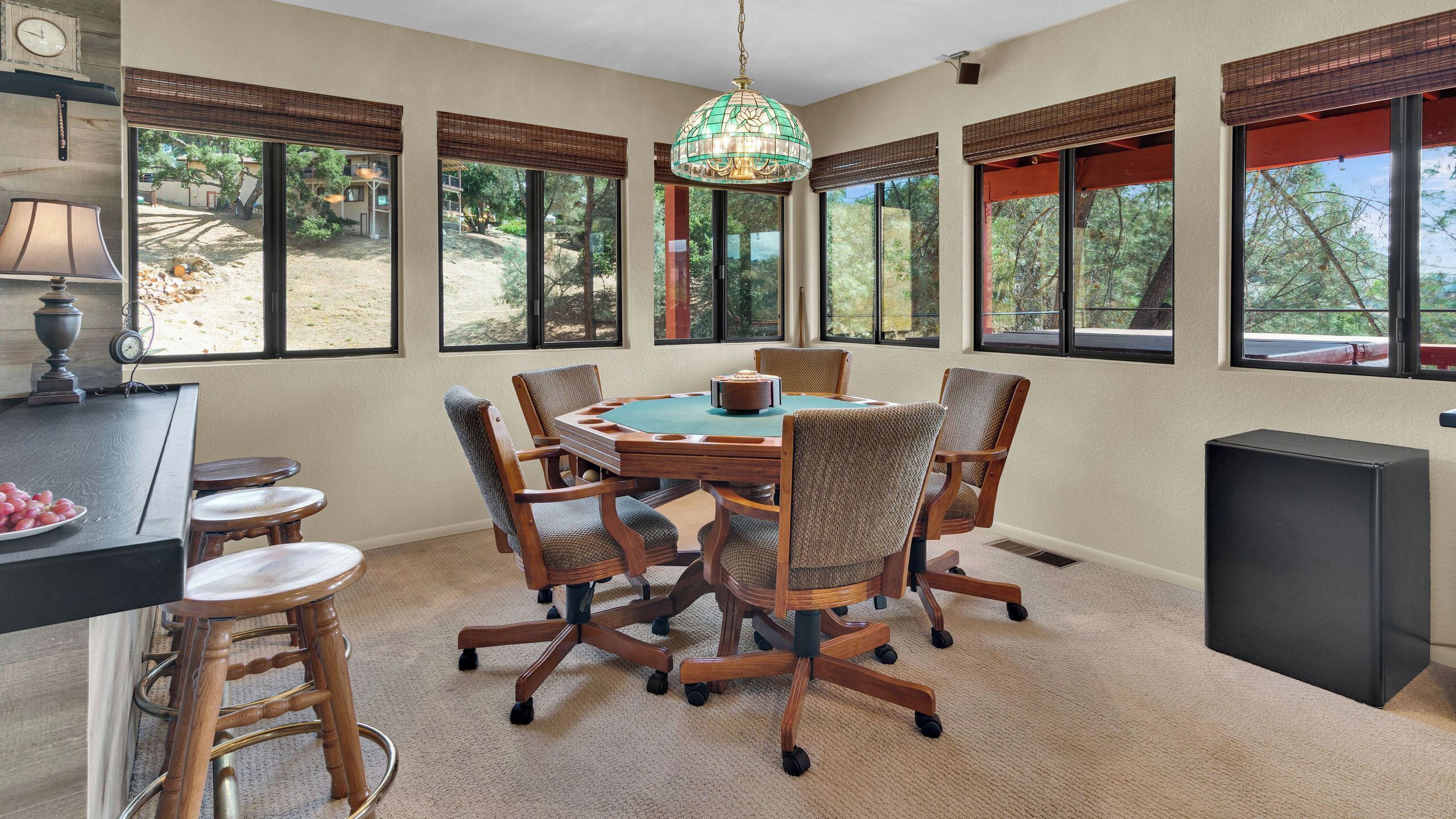 A dining area with a round table, six chairs, and a chandelier.