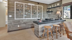 Un espace bar avec un décor en bois, un livre d’or et une bouteille de vin.