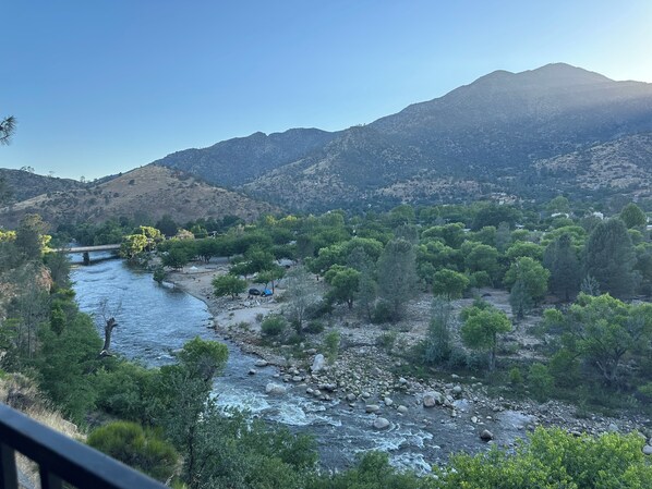 Une rivière qui traverse une vallée, avec des montagnes en arrière-plan.