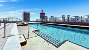 A rooftop pool with clear blue water, metal railings, and a city skyline in the background. - Miami Central Suites (Miami)