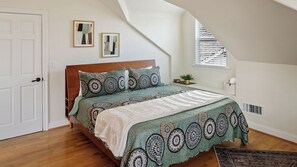 A bedroom with a bed, a window with blinds, a wall clock, and a door. - Backyard Vines on Olive by Avantstay Spa + BBQ + Big Backyard Walk to Downtown Paso (Paso Robles)