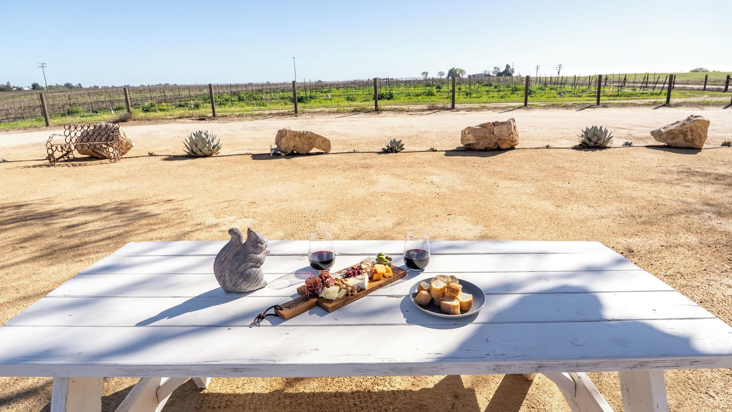 Una mesa de picnic con comida y bebidas en un entorno al aire libre.