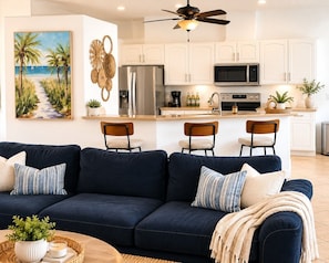 A modern kitchen with white cabinets, a stainless steel refrigerator, and a microwave. - Gullaby Getaway - Pool, Wide Canal, Sleeps 7 (Cape Coral)