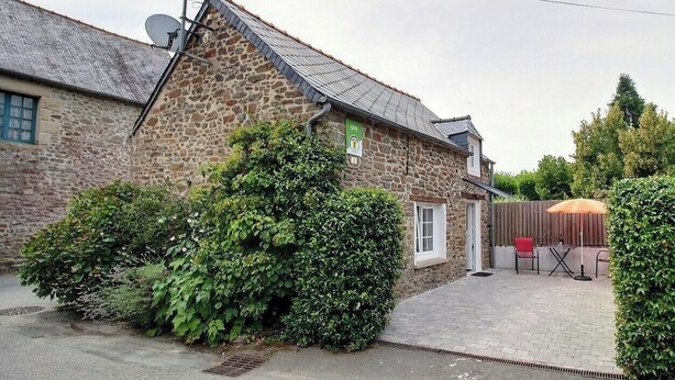 A stone building with a satellite dish, a paved driveway, and a patio with outdoor furniture. - La Petite Quinoise - PLOUER SUR RANCE (PLOUER SUR RANCE)