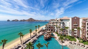 Een resort met zwembad, strand en uitzicht op de oceaan.