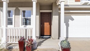 A residential house with a front porch, a brown door, and two potted plants. - Sunset Summit by Avantstay Modern Kitchen + BBQ Patio Downtown Paso Robles (Paso Robles)