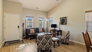 A living room with a sofa, two patterned chairs, a coffee table, a TV, and a decorative wall piece. - Sunset Summit by Avantstay Modern Kitchen + BBQ Patio Downtown Paso Robles (Paso Robles)
