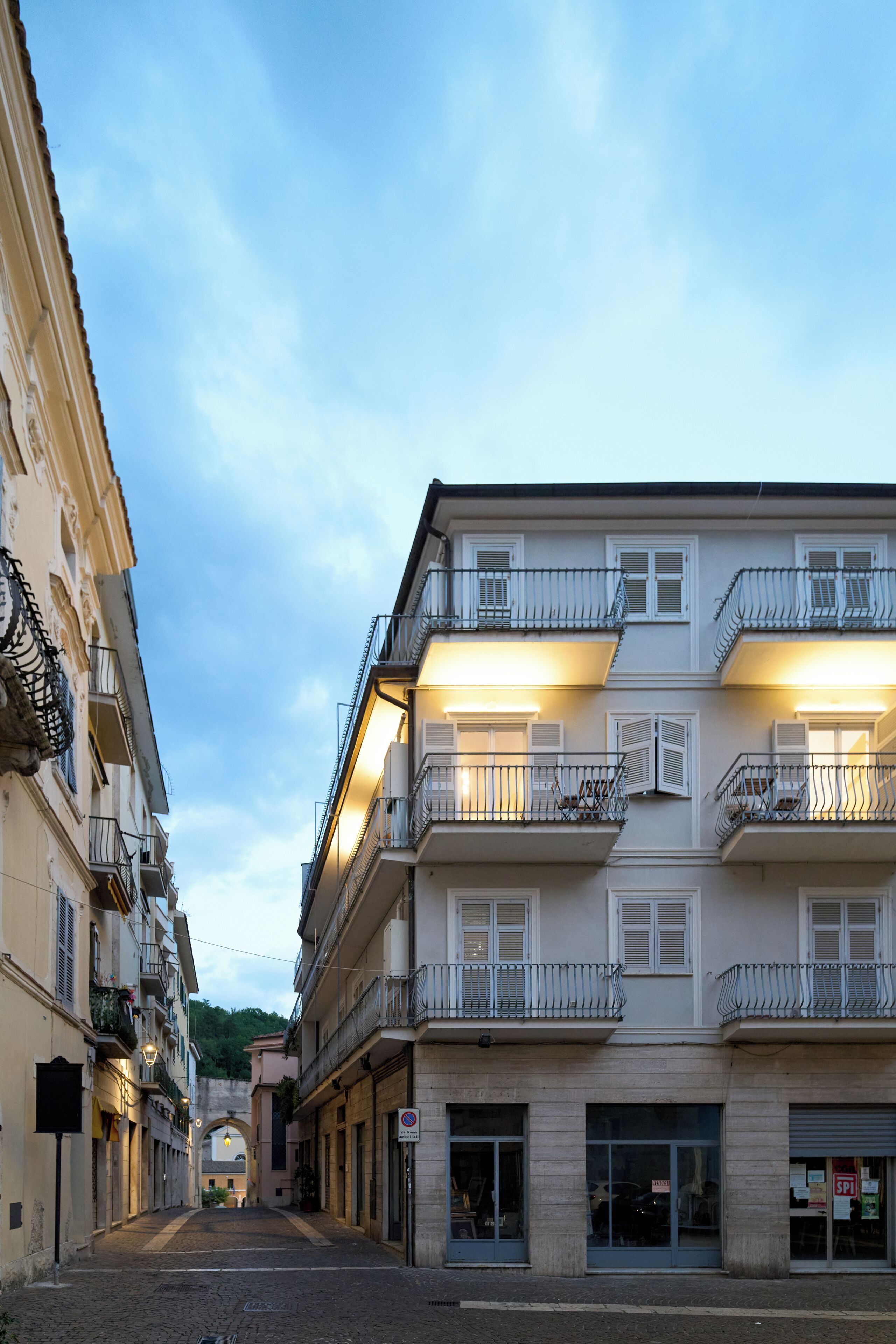 Une vue de rue avec des immeubles à plusieurs étages, des balcons et une rue pavée.