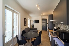 Une cuisine moderne avec un coin repas, un four encastré et une grande fenêtre.