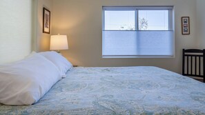 A bedroom with a bed, a window, and a wall-mounted lamp. - Quercus Acorn Cottage by Avantstay 2 King Suites + Porch Walkable Downtown Paso Robles (Paso Robles)