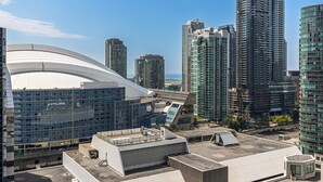 A modern urban skyline with high-rise buildings, a distinctive curved building, and a rooftop area with a small structure.