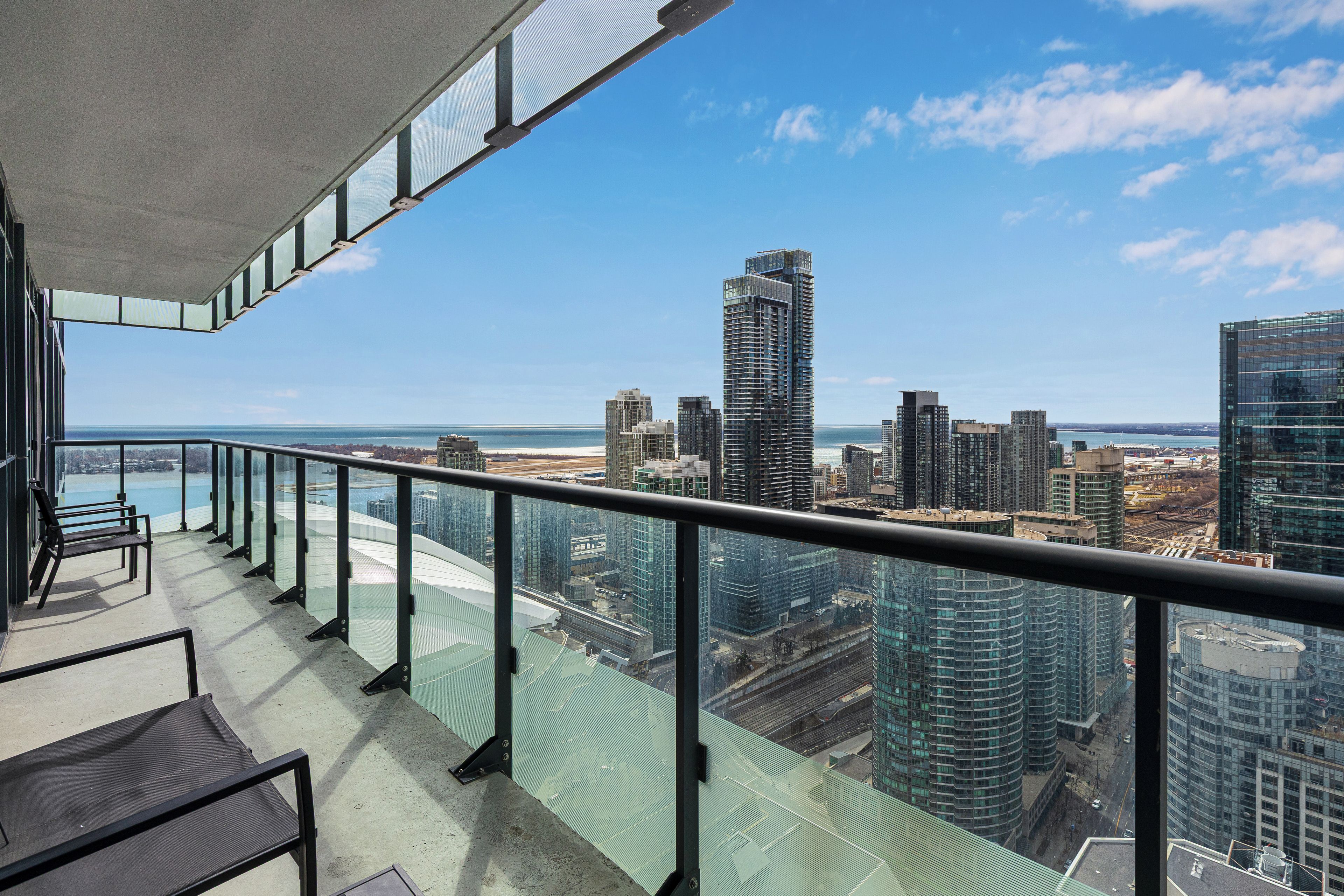 A balcony with a view of a city skyline and a body of water.