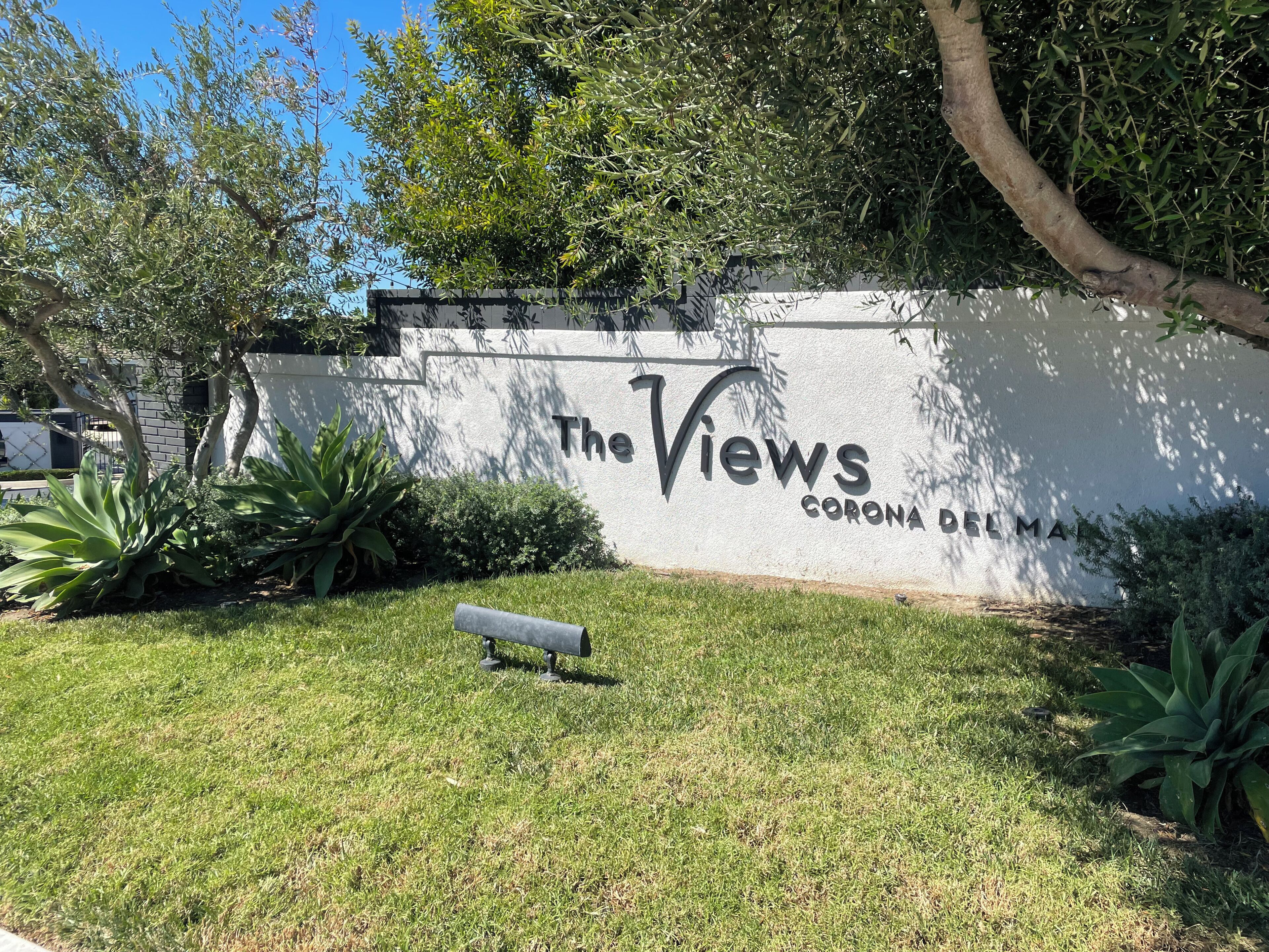 Un letrero que dice 'The Views', con una vista despejada de la vegetación circundante y un césped bien cuidado.
