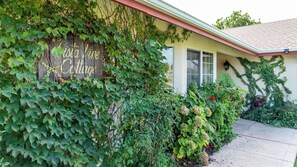A building with a sign reading 'Vista Vine Cottage' partially covered by ivy. - Vista Vine Cottage by Avantstay Panoramic Valley Views + BBQ Paso Robles Hilltop (San Miguel)