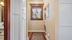 A hallway with a patterned carpet, a window with curtains, and a washing machine. - Lewis Loft by Avantstay Two Suites + Walk to Town Paso Robles (Paso Robles)