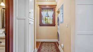 A hallway with a patterned carpet, a window with curtains, and a washing machine. - Lewis Loft by Avantstay Two Suites + Walk to Town Paso Robles (Paso Robles)