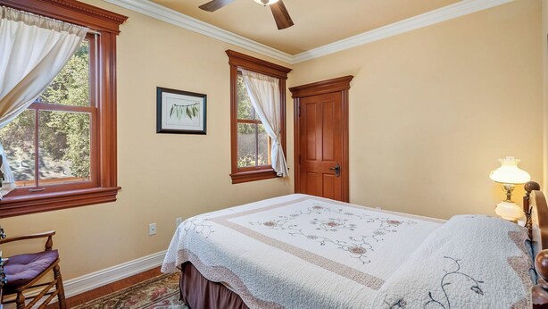 A bedroom with a bed, a chair, a window with curtains, a door, and a wall-mounted picture. - Lewis Loft by Avantstay Two Suites + Walk to Town Paso Robles (Paso Robles)