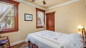 A bedroom with a bed, a chair, a window with curtains, a door, and a wall-mounted picture. - Lewis Loft by Avantstay Two Suites + Walk to Town Paso Robles (Paso Robles)