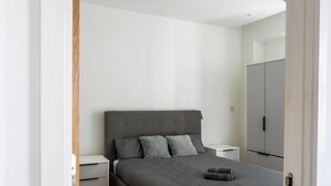 A bedroom with a bed, nightstands, a wardrobe, and a door. - Morden stay minutes from Manchester City centre (Manchester)