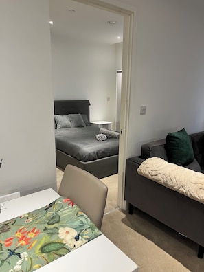 A modern bedroom with a bed, a sofa, and a table. - Morden stay minutes from Manchester City centre (Manchester)