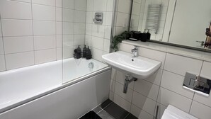 A modern bathroom with a bathtub, a sink, and a shower. - Morden stay minutes from Manchester City centre (Manchester)