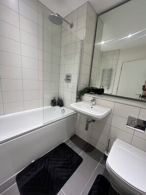 A modern bathroom with a bathtub, a sink, and a shower. - Morden stay minutes from Manchester City centre (Manchester)