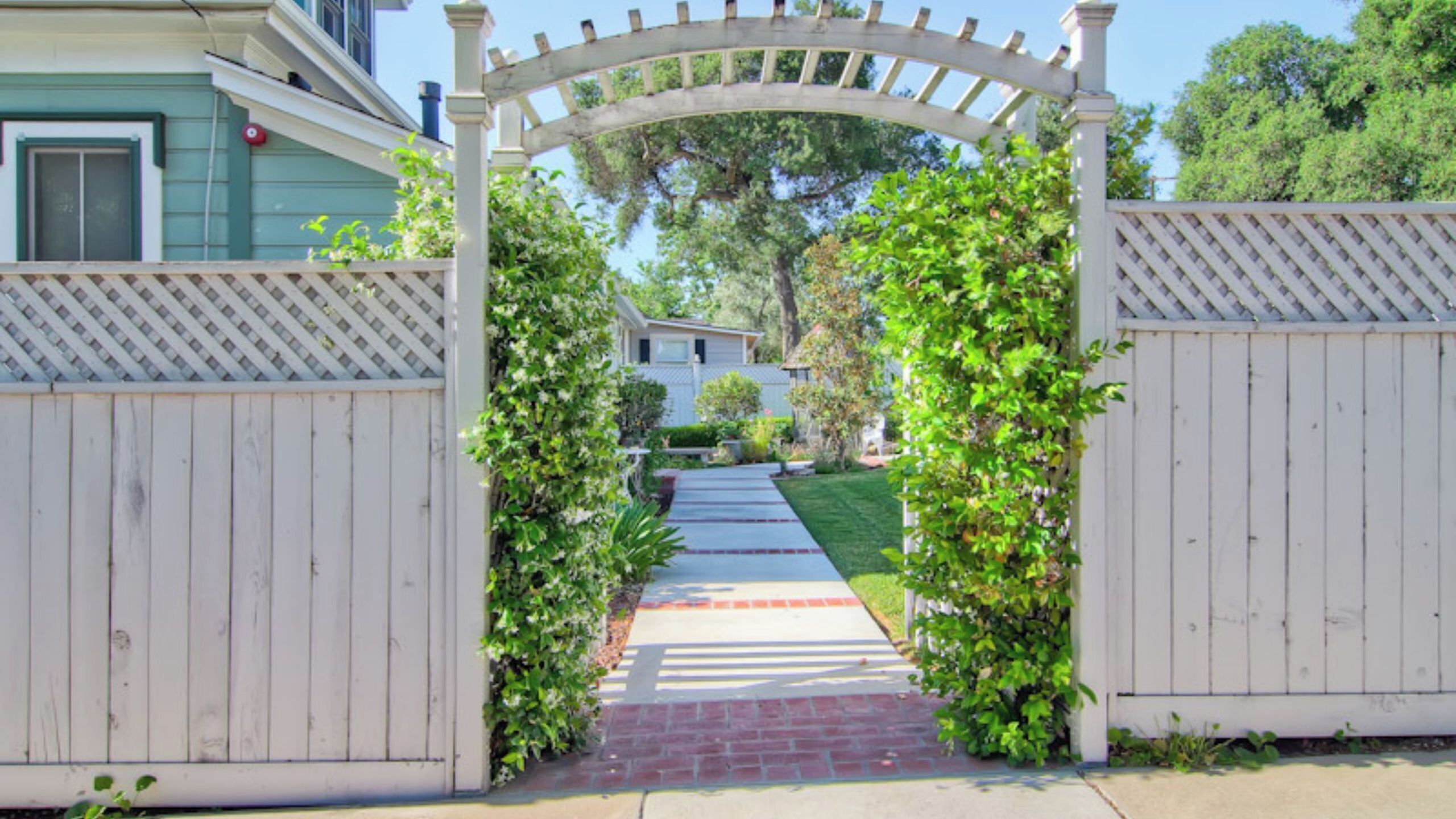 A gated entrance with a wooden archway leading to a pathway.