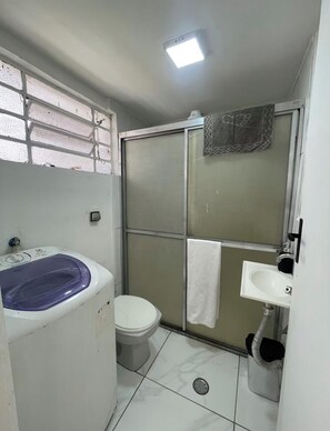 A small bathroom with a toilet, a bathtub, and a shower enclosure. - House 4 in the Anglo-Brazilian Village (São Paulo)