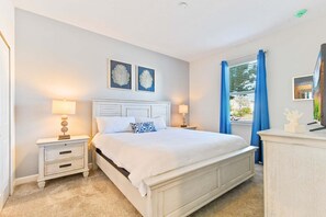 A bedroom with a bed, two bedside tables with lamps, a dresser, and a window with curtains. - Storey Lake Resort Villa | Pool & Resort Fun (Kissimmee)